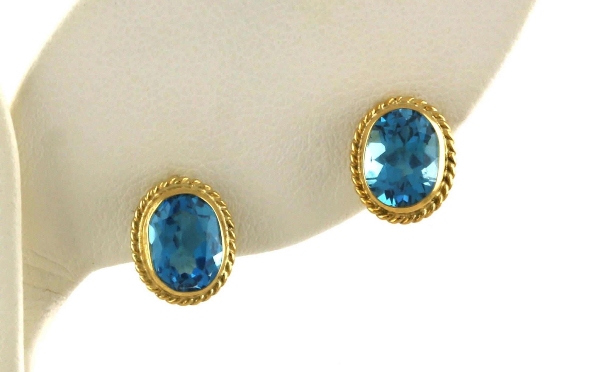 Bezel-set Oval Blue Topaz Stud Earrings with Rope Edge Detail in Yellow Gold 